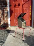 Almost indestructible metal squirrel feeder on small metal chair.