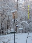 Snow on Bluebird house, birdbath & feeders.