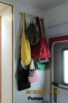 Purses on the coat hooks by the front door.