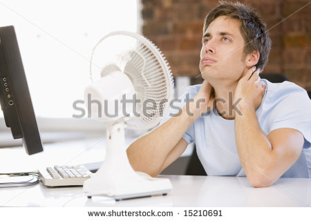 stock-photo-businessman-in-office-with-computer-and-fan-cooling-off-15210691